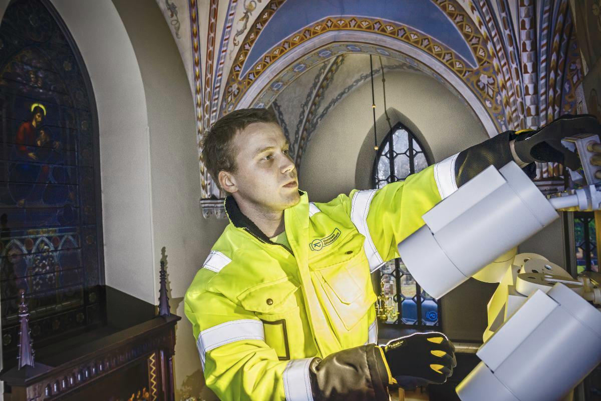 Sähköasentaja Mihkel Mikson on työskennellyt Pyhän Laurin kirkossa kesäkuusta alkaen. Viimeksi hän on asentanut spotteja kirkon kuoriosaan. Kuva: Hans von Schantz