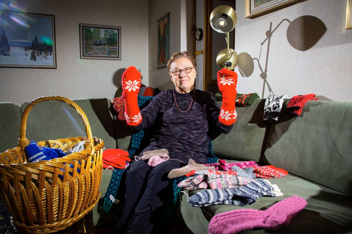 Irma Koski esittelee tekemiään sukkia ja lapasia. Hän on huomannut, että kutominen on hyvää puuhaa vaikka yöllä, kun ei saa unen päästä kiinni.