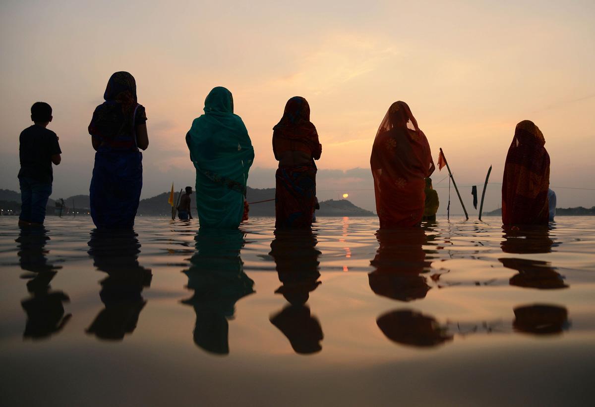 Hindut rukoilevat auringolle omistetussa chatth-juhlassa Brahmaputra-joen rannalla Intiassa. Juhlassa kiitetään aurinkoa siitä, että se suuressa anteliaisuudessaan lahjoittaa elämän edellytykset maapallolle.