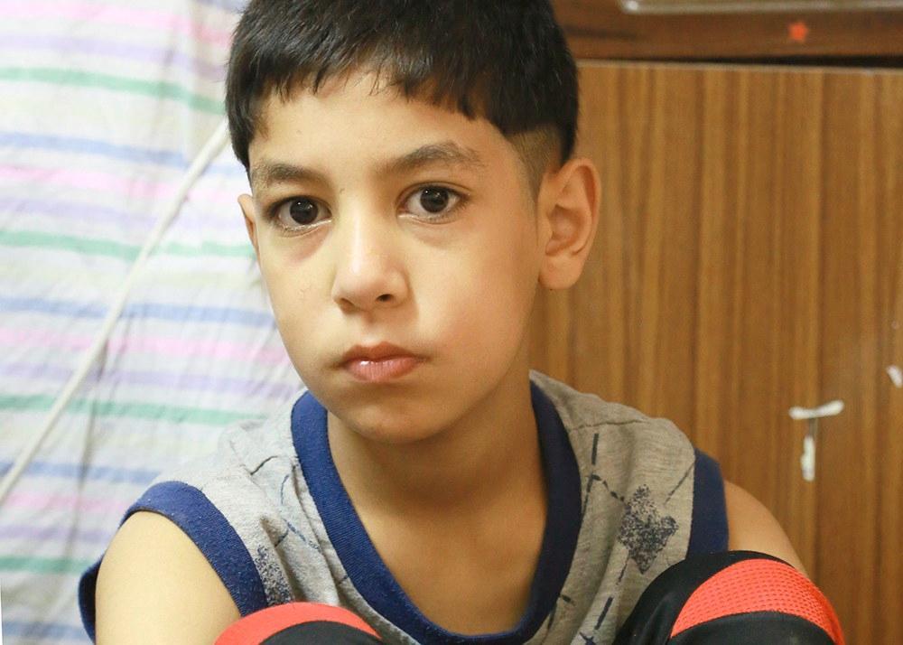 Tämä poika matkusti perheensä kanssa Syyriasta Jordaniaan lampaidenkuljetusautolla. Kyydissä oli 90 ihmistä. Matka kesti 12 tuntia. Kotoa lähdettiin, kun kotikaupungissa alkoivat pommitukset. Perhe pakeni, mutta sota levisi muihin kaupunkeihin. Kouluun oli vaarallista mennä. Isoveli oli nähnyt, miten ihmisiä tapettiin kadulla. Perhe asui kuukauden pakolaisleirillä, jonka jälkeen he saivat Jordaniasta asunnon.