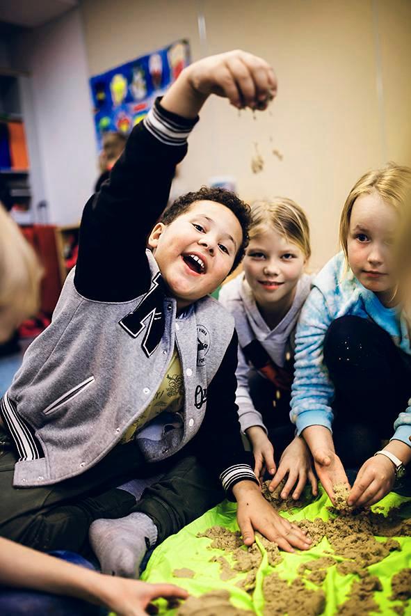 Jalen Plummer on tehnyt hiekasta pallon. Emma Suominen ja Essi Toppila katsovat, säilyykö se ehjänä.