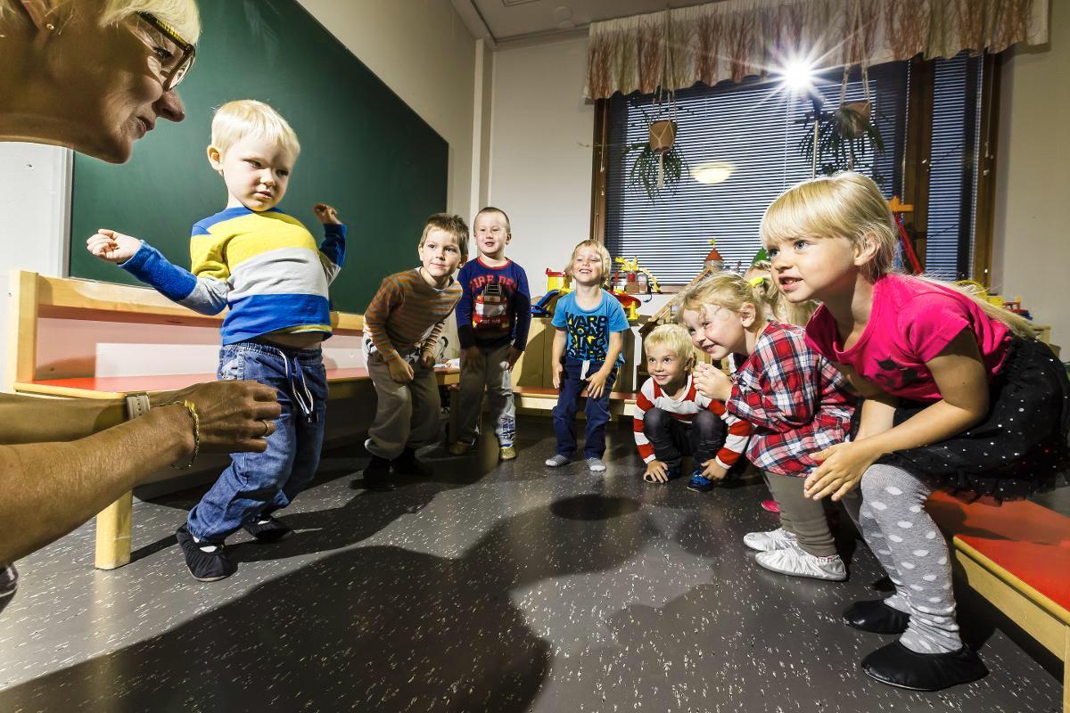 Taukojumppaa! Otso, Noa, Axel, Oula, Aadel, Pihla ja Julia leikkivät laulaen Taimi Koiviston (vas.) kanssa. Kuva: Jukka Granstrom