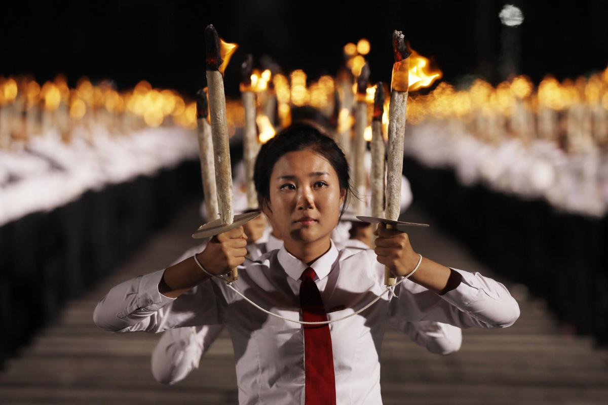 Nuoria soihdunkantajina Pohjois-Korean perustamispäivän juhlissa Pythonissa Pohjois-Korean Pyongyangissa 10. syyskuuta 2018. Kuva: Kin Cheung / AP – Lehtikuva