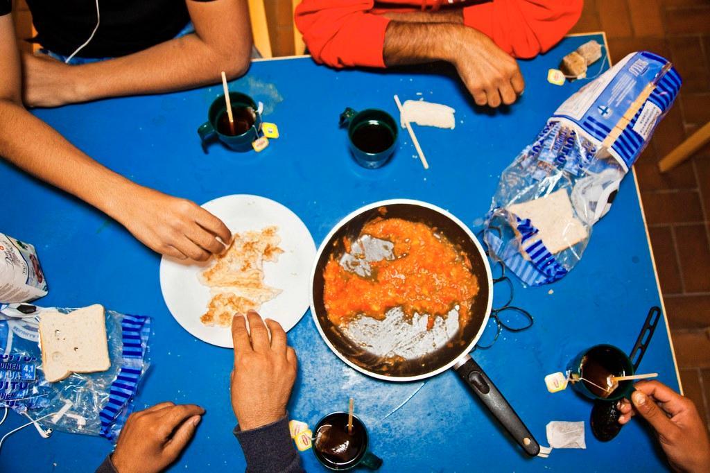 Turvapaikanhakijat syövät yhdessä Munkkiniemen vanhalla seurakuntatalolla. Kuva: Sirpa Päivinen. 