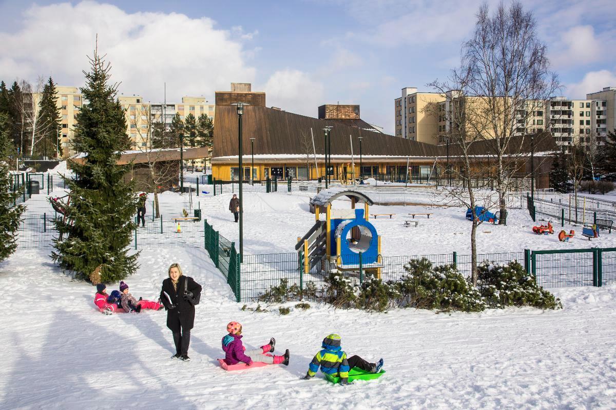 Pirkko Sillanpää kävi Suvelan asukaspuistossa. Alueen näkymä on muuttunut melkoisesti vuodesta 1991, kun matalan rakennuksen tilalle on tullut kappeli.