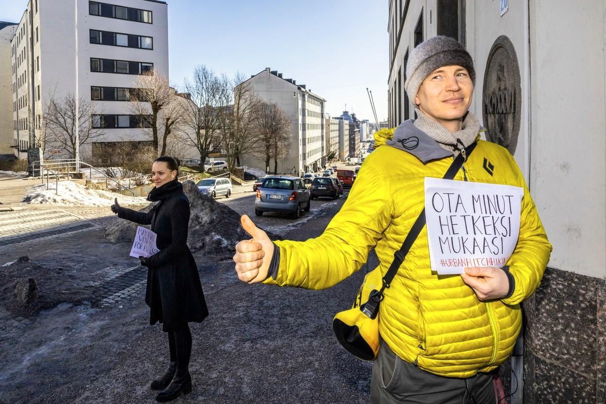 Helena Vartiainen ja Lauri Jäntti näyttävät, miten kaupunkiliftataan: peukalo pystyyn, kyltti esiin ja katse ohikulkijoihin. Helpoiten kyydin saa aurinkoisella säällä ja yksin.