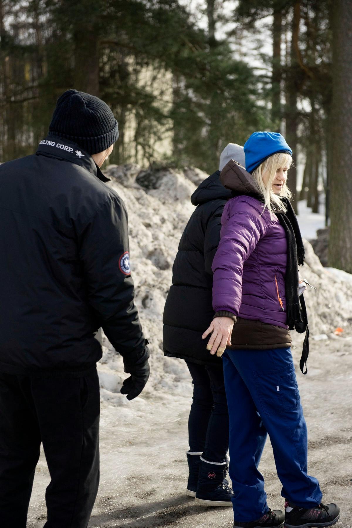 Lähihoitaja Annikki Mustonen ulkoilee asukkaiden kanssa.