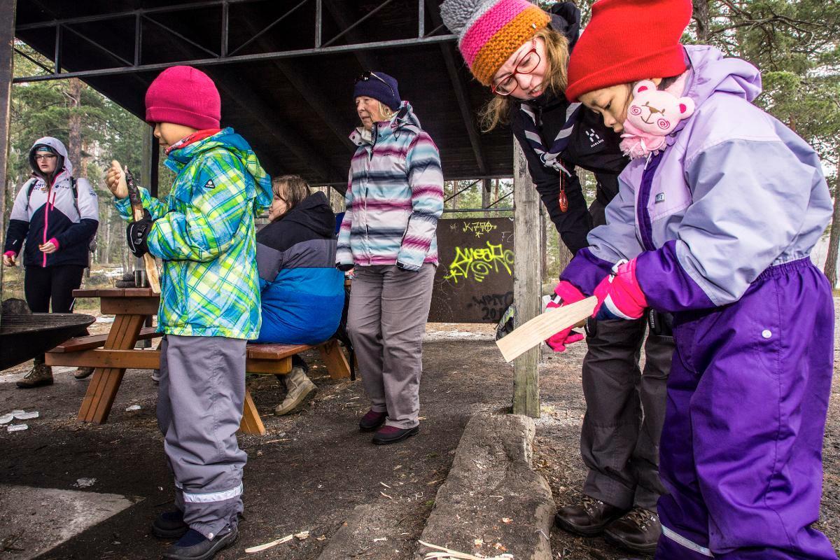 Mellunkylän lasten projektipäällikkö Riikka Nenonen näyttää Lin Chengjielle, miten vuollaan. Holly Fleming (vasemmalla), Lin Biying, Maria Nurmi ja Krista Ruutuoksa pitävät taukoa.