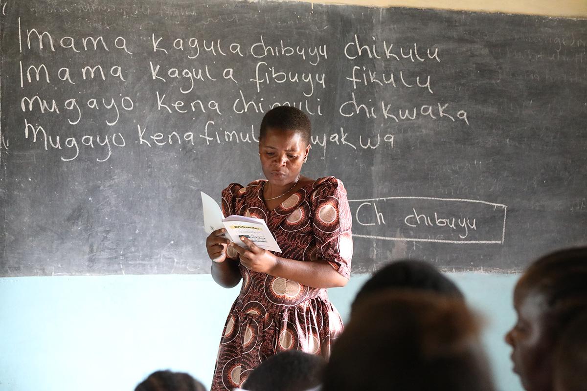 Lukutaito-opettaja luokan edessä. Lukemaan oppiminen omalla kielellä on perustava ihmisoikeus ja elämän suuri käännekohta. 