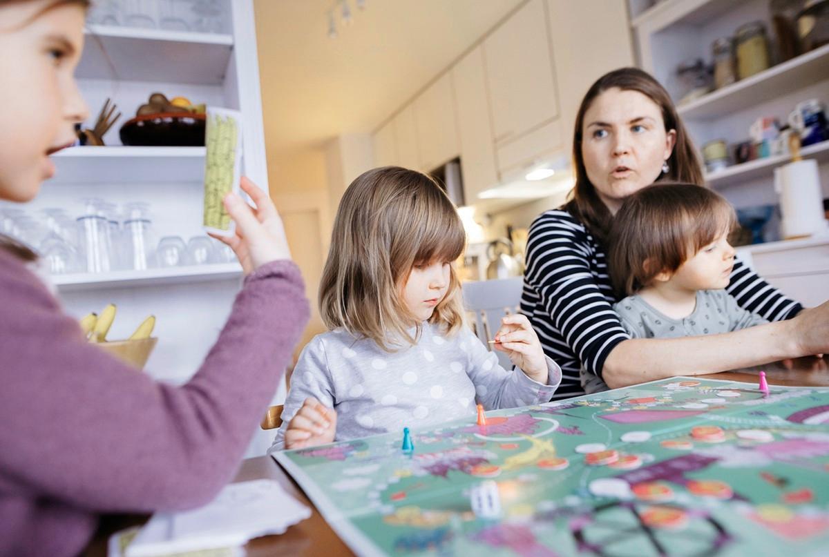 Perla ja Noa Rodriguez sekä Mira Alanne pelaavat Kultainen sulka -peliä, joka harjaannuttaa esimerkiksi myötätuntoa. Alanteen sylissä on Elsa-kuopus.