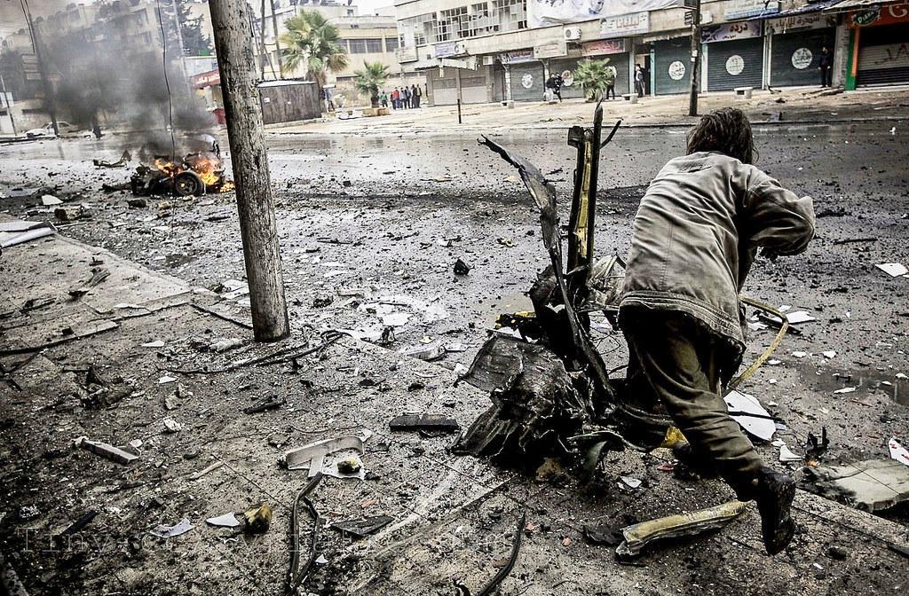 Mies siirtää autonromua kranaatti-iskun jälkeen Aleppossa joulukuussa 2012. Kuva: Flickr / Freedom House 