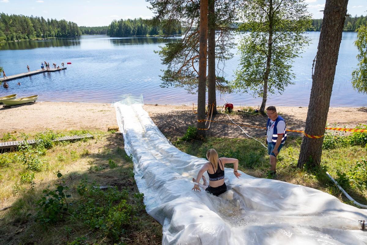 Hilda Simpanen laskee vesiliukumäessä. Leiriläiset pääsivät kokeilemaan myös telttasaunaa ja sup-lautailua.