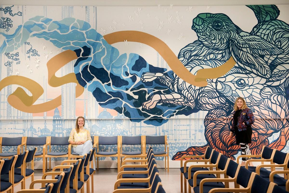 Essi Ruuskanen (vas.) maalasi muraaliin sinisen virran, Maikki Rantala jättimäiset jänikset.