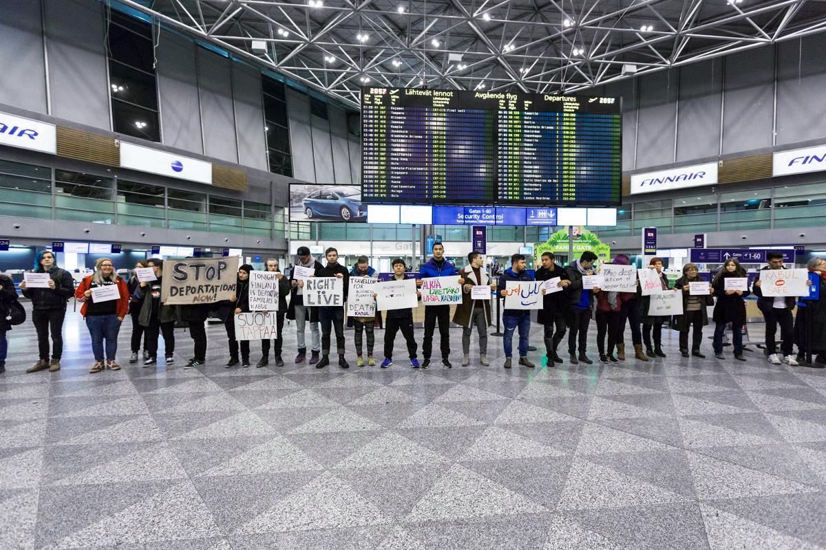 Lentoasemalle saapuneet mielenosoittajat seisoivat kyltteineen lähtöaulassa.