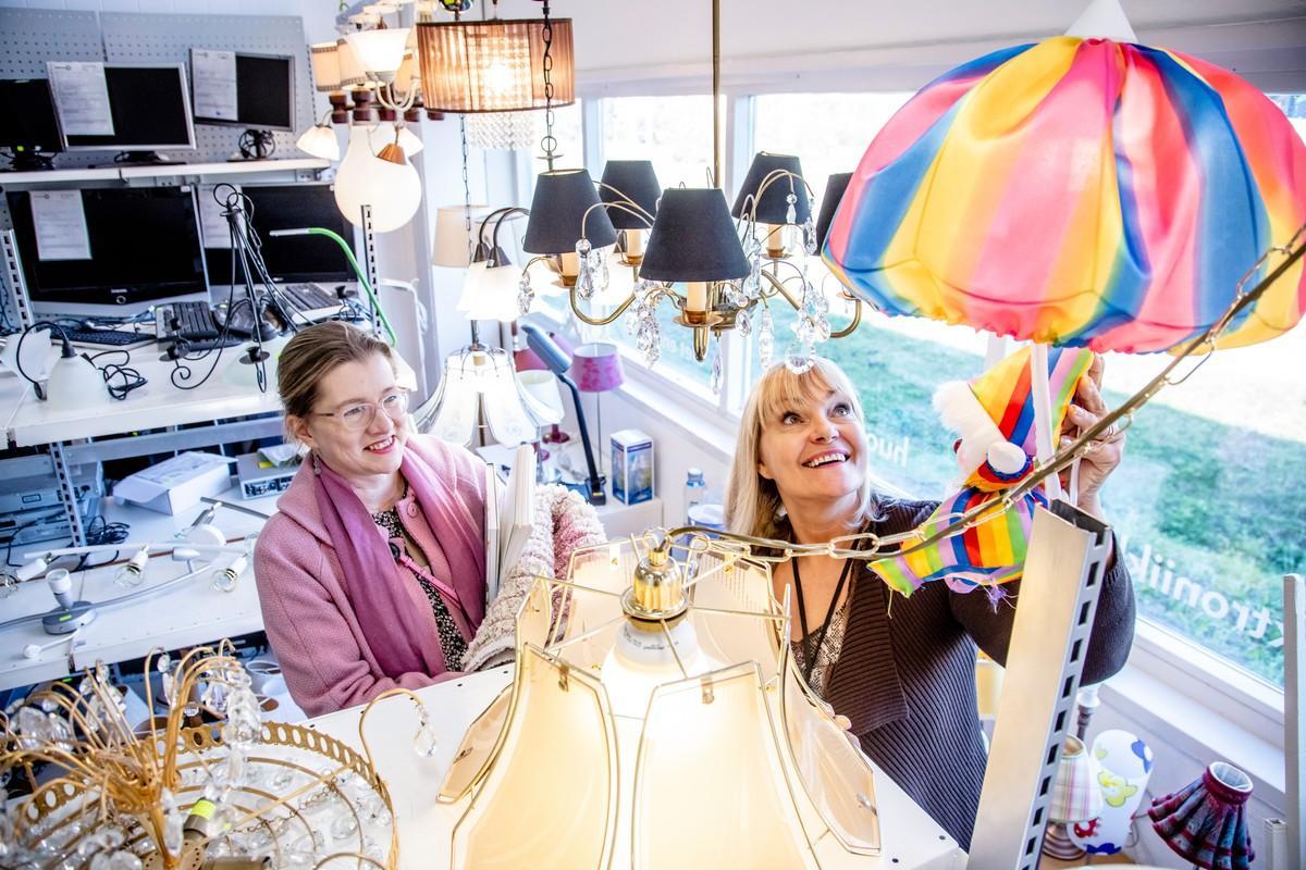 Myymäläpäällikkö Peppi Mattila (oik.) esittelee kirjailija Laura Honkasalolle Porttipuiston kierrätyskaupassa myynnissä olevia lampunvarjostimia.