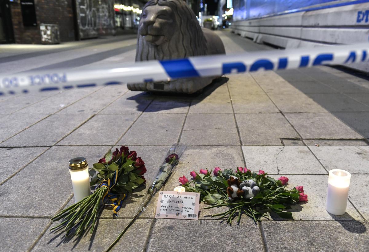 Ihmiset ovat tuoneet kukkia ja kynttilöitä lähelle tapahtumapaikkaa Tukholman keskustassa. Kuva: Maja Suslin/TT NEWS AGENCY/Lehtikuva.