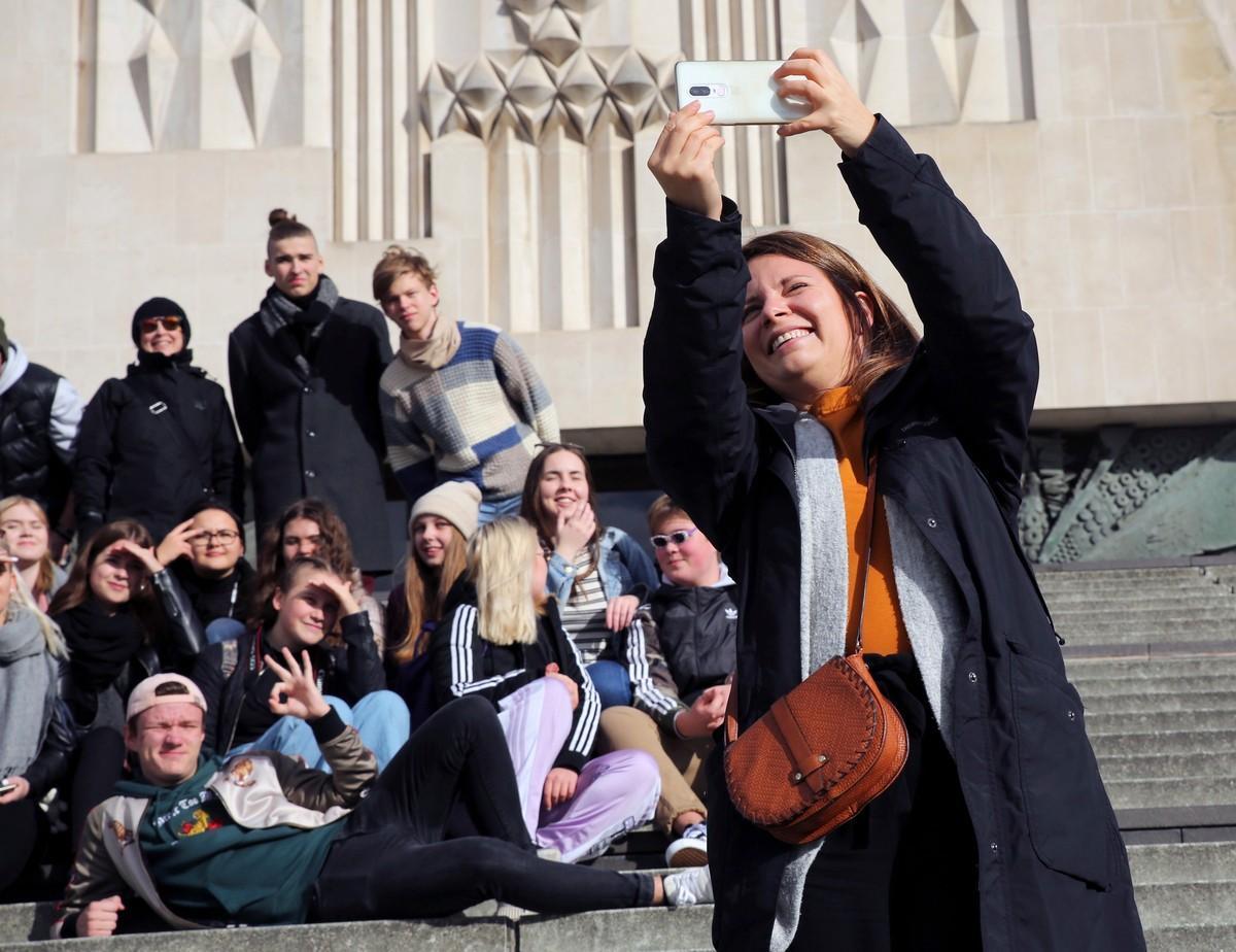 Nuorisotyönohjaaja Riikka Hillebrand ottaa selfien isosryhmän kanssa.