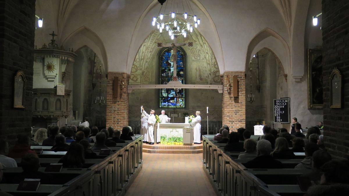 Pääsiäisyönä hämärään kirkkoon syttyy täysi valaistus. Kuva on Espoon tuomiokirkon pääsiäisyön messusta vuodelta 2015.
