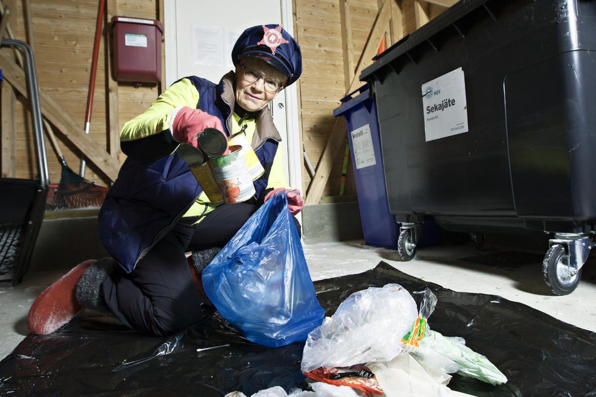 Roskapoliisi Heini Manninen, 65, tarkistaa taloyhtiönsä jätehuoneen. Kuva: Saara Vuorjoki