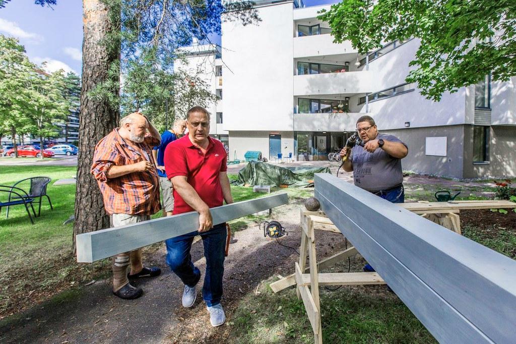 Kohta nousee. Jari Rautanen, lähihoitaja Toni Männikkö, Sanervakodissa työhönoppimisjaksolla oleva Kai Hurri ja vuokralainen Harri Nieminen rakentavat tupakkakatosta. Kuva: Esko Jämsä