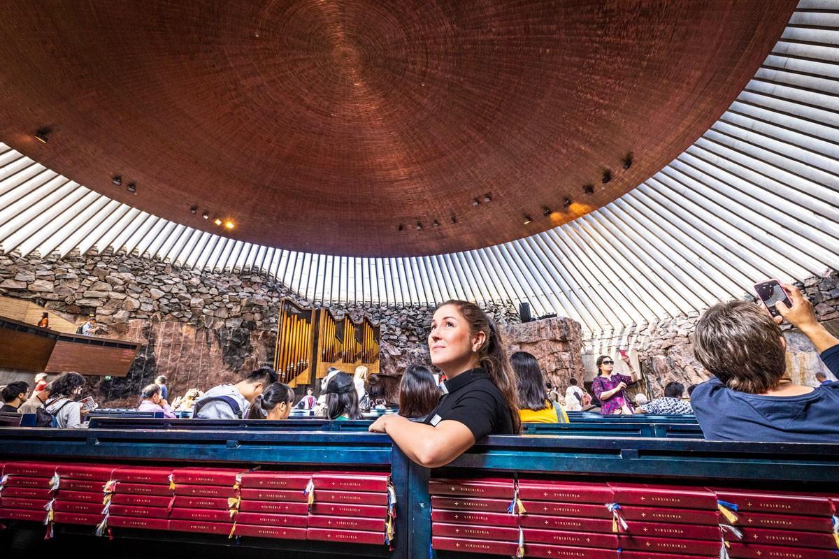 Turistipappi Piia Klemi istui Temppeliaukion kirkon penkissä heinäkuussa.