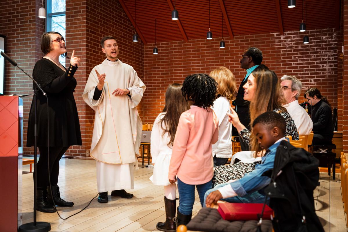 Pappi Kristian Willis kutsui lapset kirkon etuosaan, ja toista kertaa messuun osallistuva Annika Maxwell (vas.) laulatti lapsia.