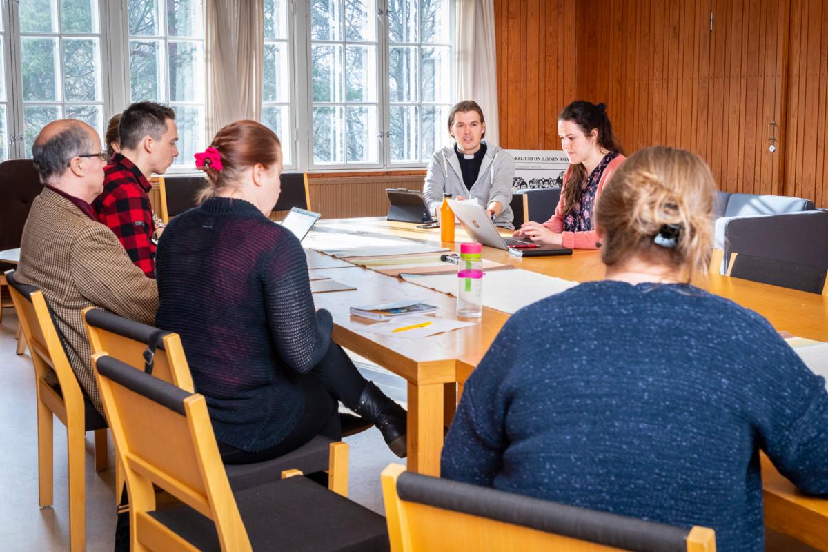 Haagan seurakunnan papit Miika Kolari (punapaitainen vasemmalla), Heikki Nenonen (harmaahupparinen keskellä) ja Minna Kumpukallio (näpyttelee tietokonetta keskellä) eivät koe asiakseen pohtia, joutuvatko haagalaiset kadotukseen.