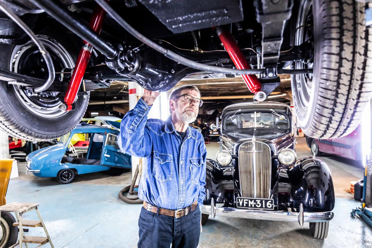 Onni Tuominen huoltaa punaista Fiat 1200 Cabrioletia, joka pitää saada valmiiksi vappukruisailulle. Taustalla näkyy Hautaustoimisto Mikko Monosen kalustoon kuuluva Chevrolet vuodelta 1936. Tuominen arvelee sen olevan Suomen vanhin ruumisauto.