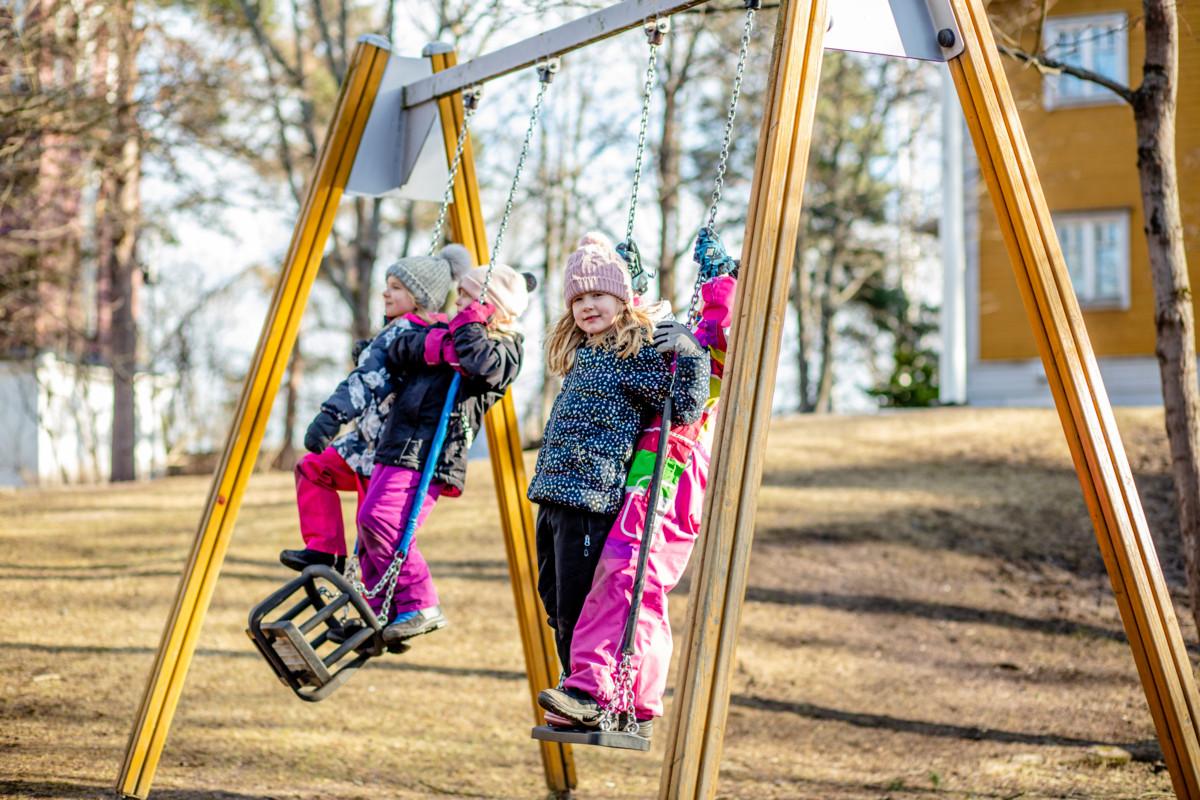 Ellen Kvest, Isabella Koskela, Oona Vainio ja Pihla Sämpi keinuvat kirkonmäellä. Kerhossa ulkoillaan ainakin tunti päivässä.