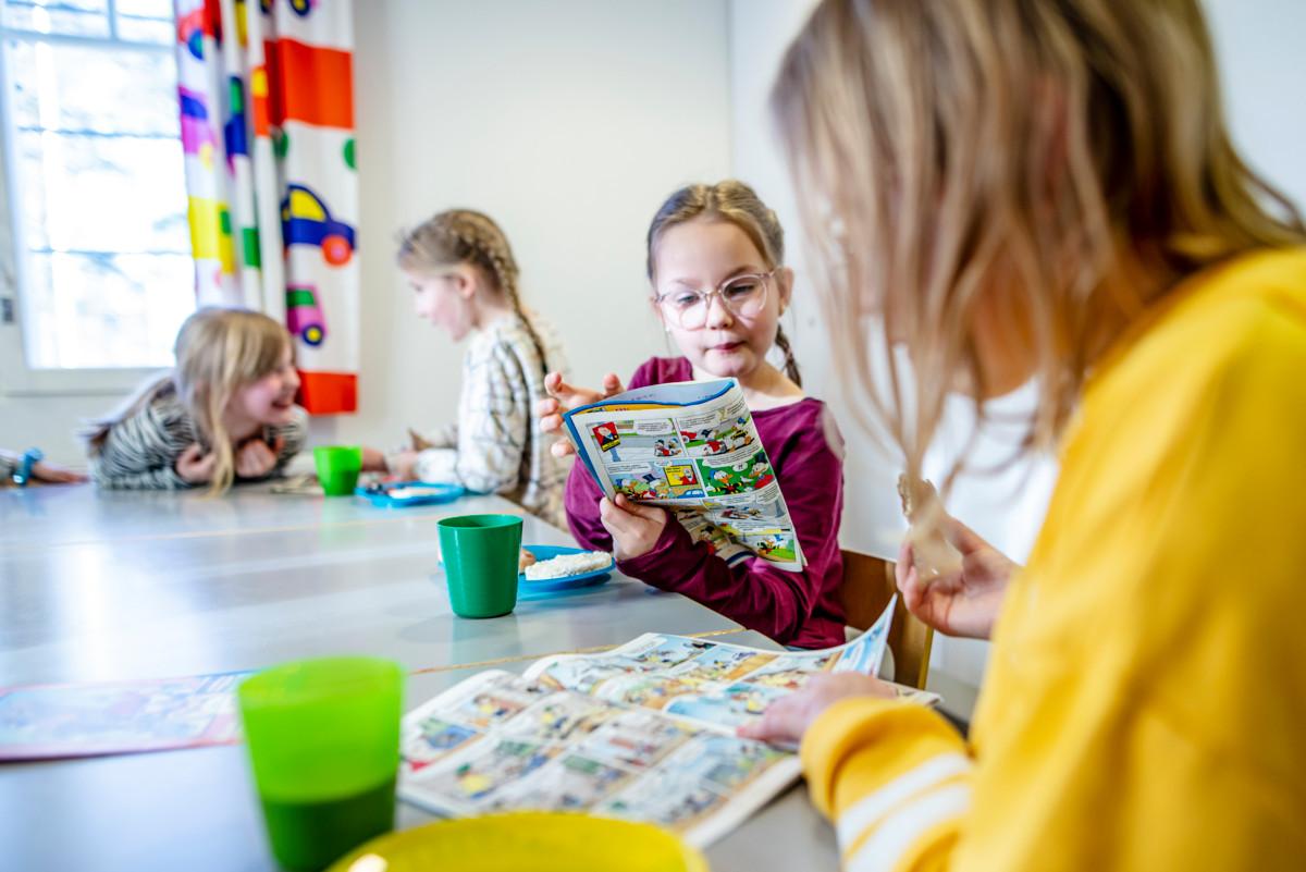 Rauhallinen hetki. Elna Tiensuu (keskellä) ja Ainu Nuottakari syventyvät sarjakuviin.