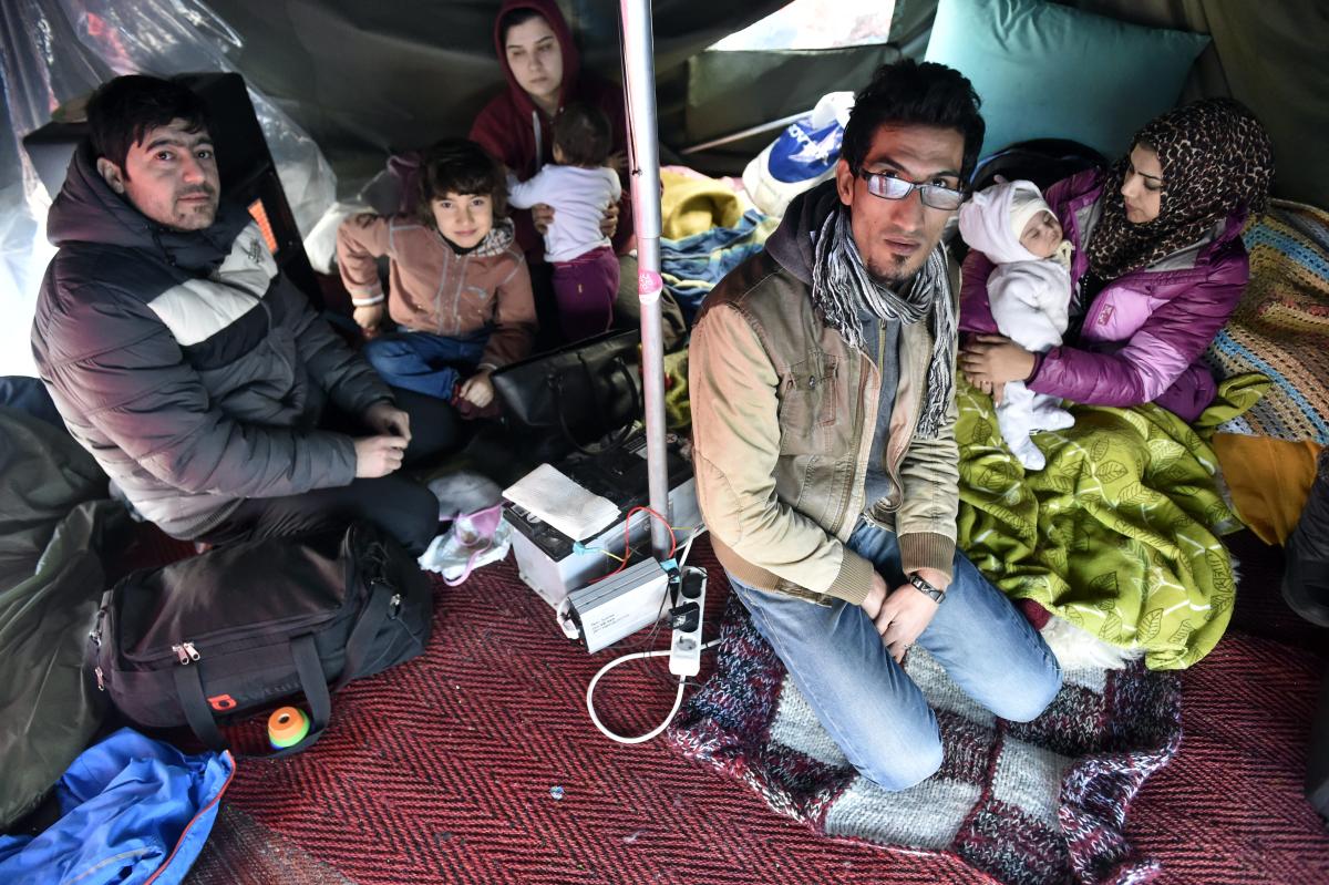Irakilainen Tara (toinen oik.) ja hänen perheensä lämmittelivät teltassa Helsingin rautatienaukiolla maaliskuussa. Pakkopalautuksia vastustava telttamielenosoitus on jatkunut monta kuukautta.