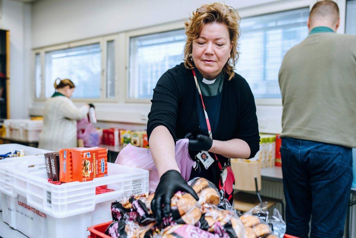 Tikkurilan seurakunnan diakoniatyöntekijä laittaa ruokaa avustuskassiin.