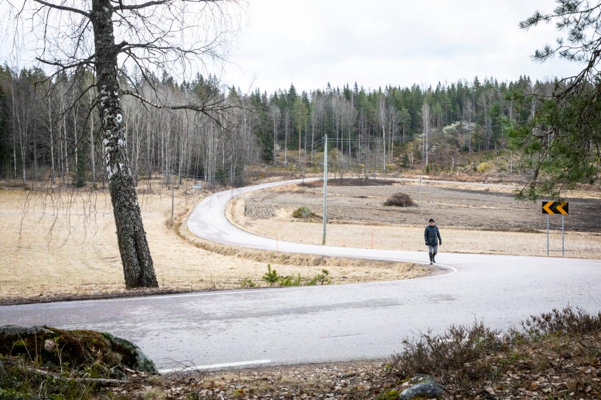 Asko Leinonen kävelee Velskolantiellä. Seurakuntien metsä, joka nyt halutaan suojella, jää hänen selkänsä taakse.