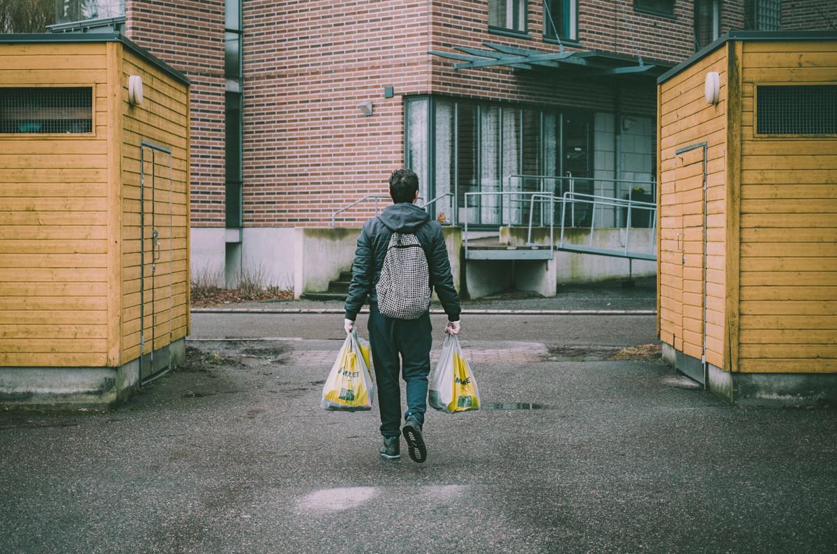 Tässä tulee Helsinki-apua. Vapaaehtoinen tuo vanhuksen ruokaostokset kotiovelle.