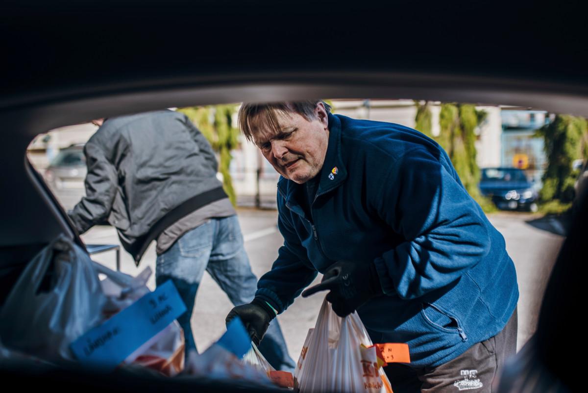Jomppa Väisänen pakkaa seurakunnan hätäruoka-apua autoonsa Hakunilan kirkon pihalla.