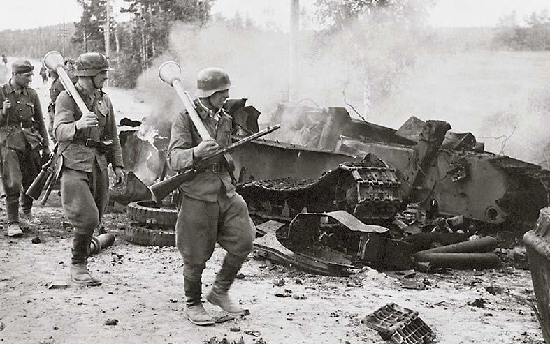Panssarinyrkein varustetut suomalaiset ohittavat saksalaisen rynnäkkötykin tuhoaman tankin.