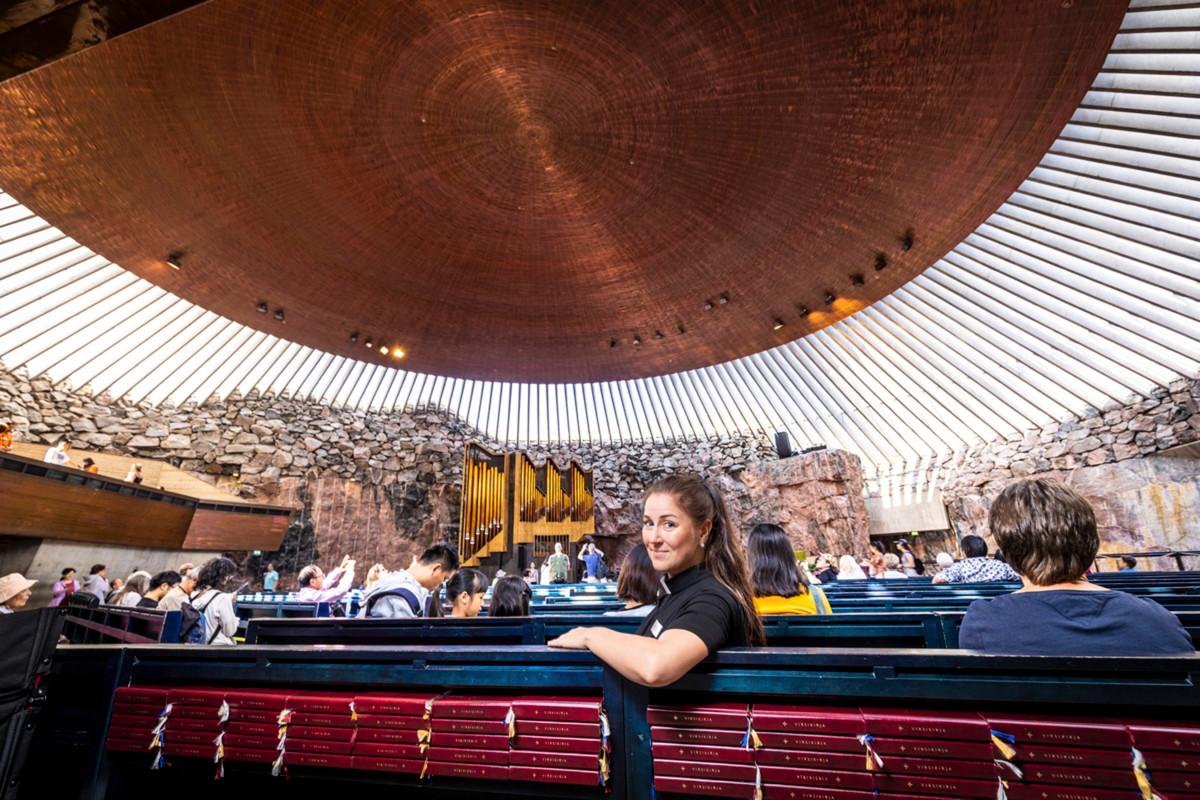 Turistipappi Piia Klemi Temppeliaukion kirkon penkissä viime vuoden heinäkuussa, kun ajat olivat toiset ja kirkossa riitti kävijöitä.