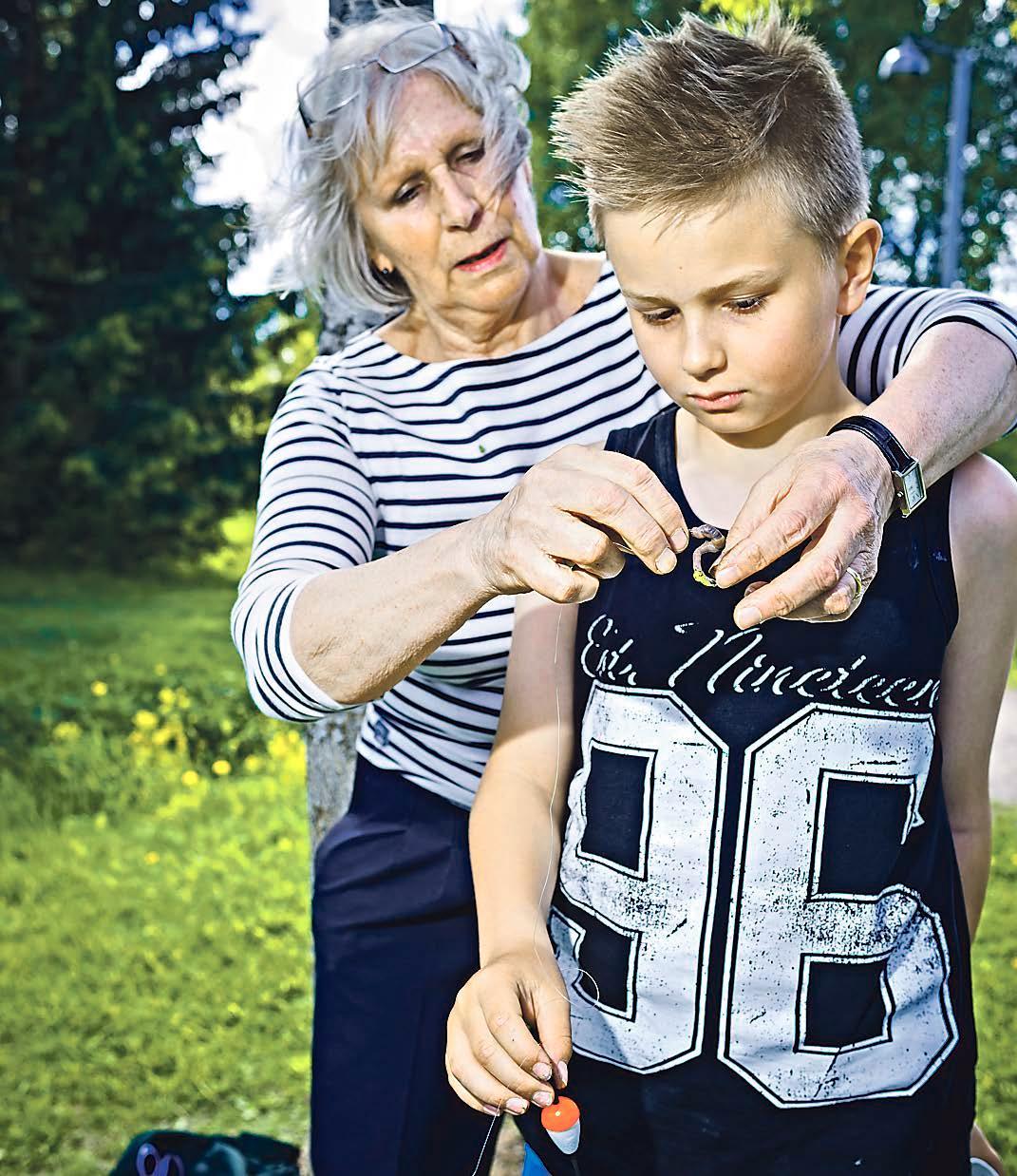 Anna-Maija Pautola laittaa lapsenlapsensa Danielin onkeen madon.