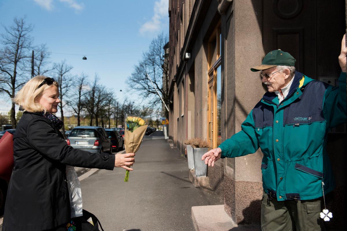 Susanna Savela ojentaa Olavi Satamavuorelle kukkakimpun, kun he kohtaavat ensimmäisen kerran toisensa Olavin kodin edustalla Hakaniemessä.