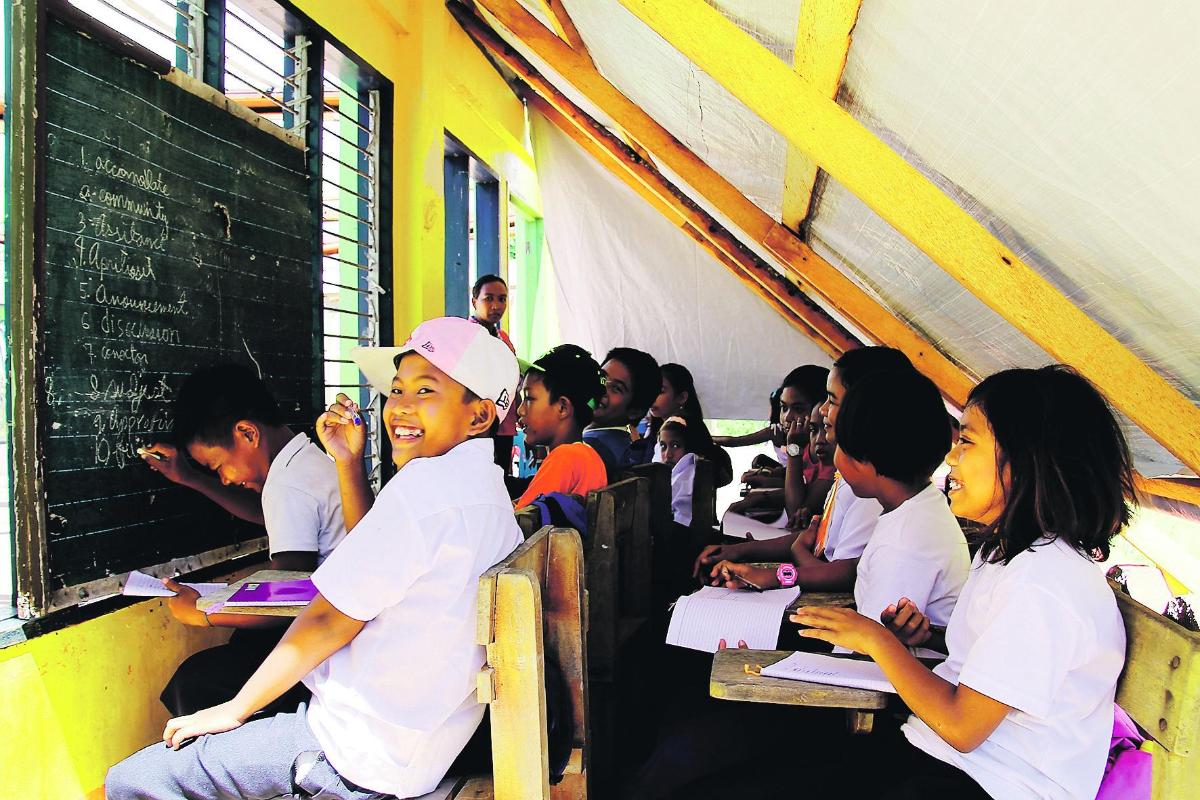 Väliaikaista vain. Anuronin koulussa opiskellaan muovipressun alla. Taifuuni Haiyan tuhosi 160 oppilaan koulun lähes täysin.