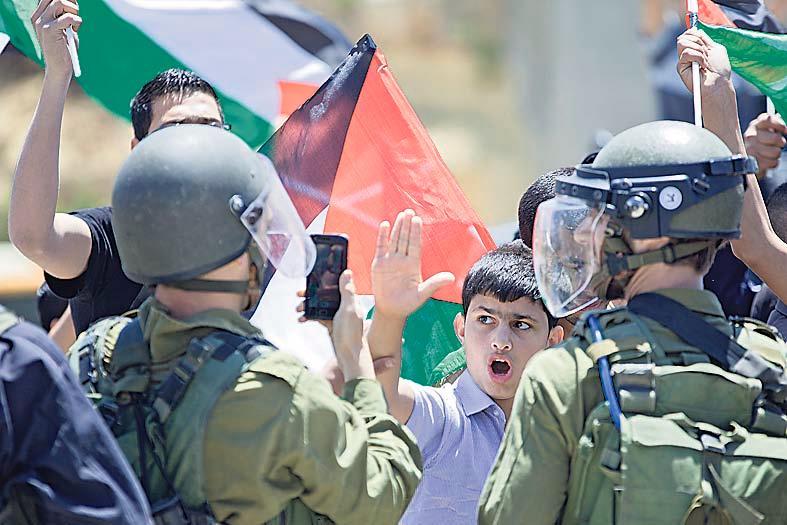 Palestiinalaispoika osoittaa mieltään vangitun 15-vuotiaan veljensä puolesta.