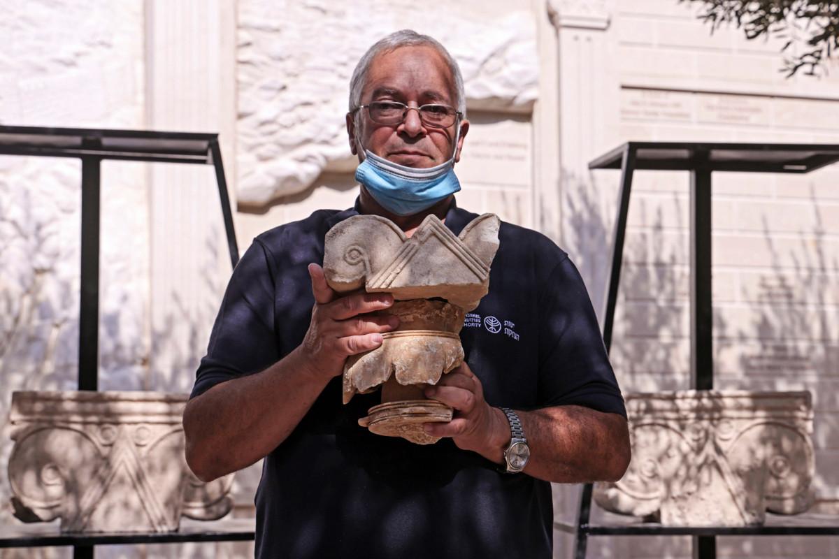 Israelin valtion antiikkiviraston johtaja Yaakov Billig pitää kädessään kaivauksissa löytynyttä 2 700 vuotta vanhaa kalkkikivipylvään päätä. 