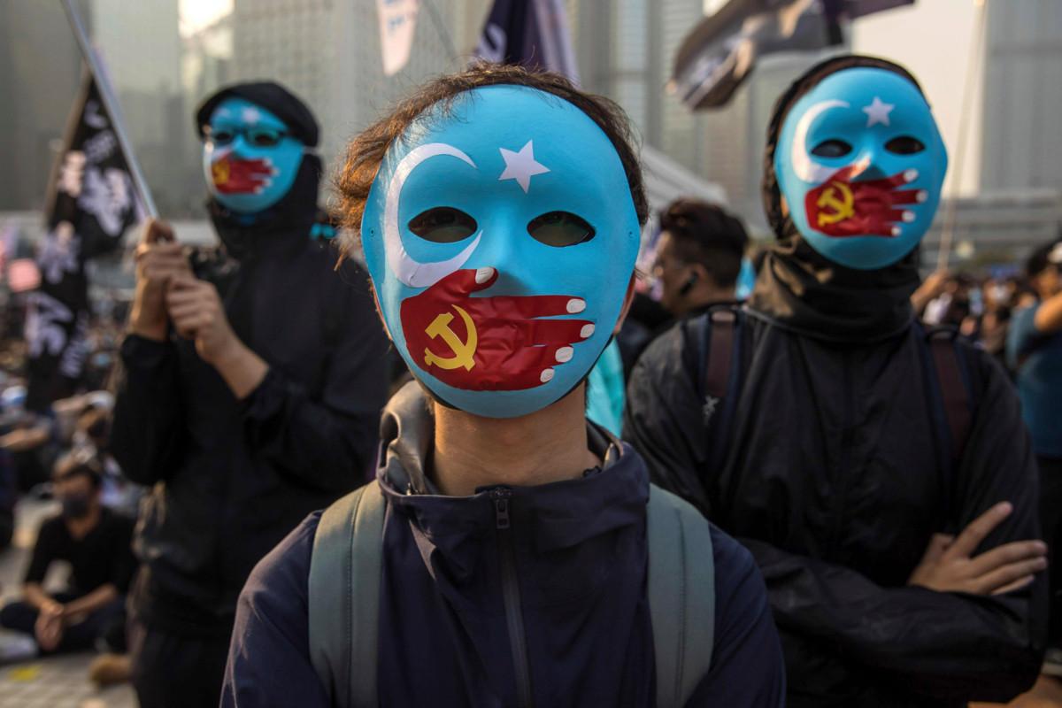 Kiina on useaan otteeseen ollut YK:n ihmisoikeusneuvoston jäsenmaa, vaikka sen ihmisoikeustilanne huolestuttaa ihmisoikeusjärjestöjä. Kuvan mielenosoittajat ilmaisivat tukensa Kiinan sortamalle uiguuriväestölle Hongkongissa joulukuussa 2019. Kuva: Dale de la Rey / Lehtikuva / AFP.