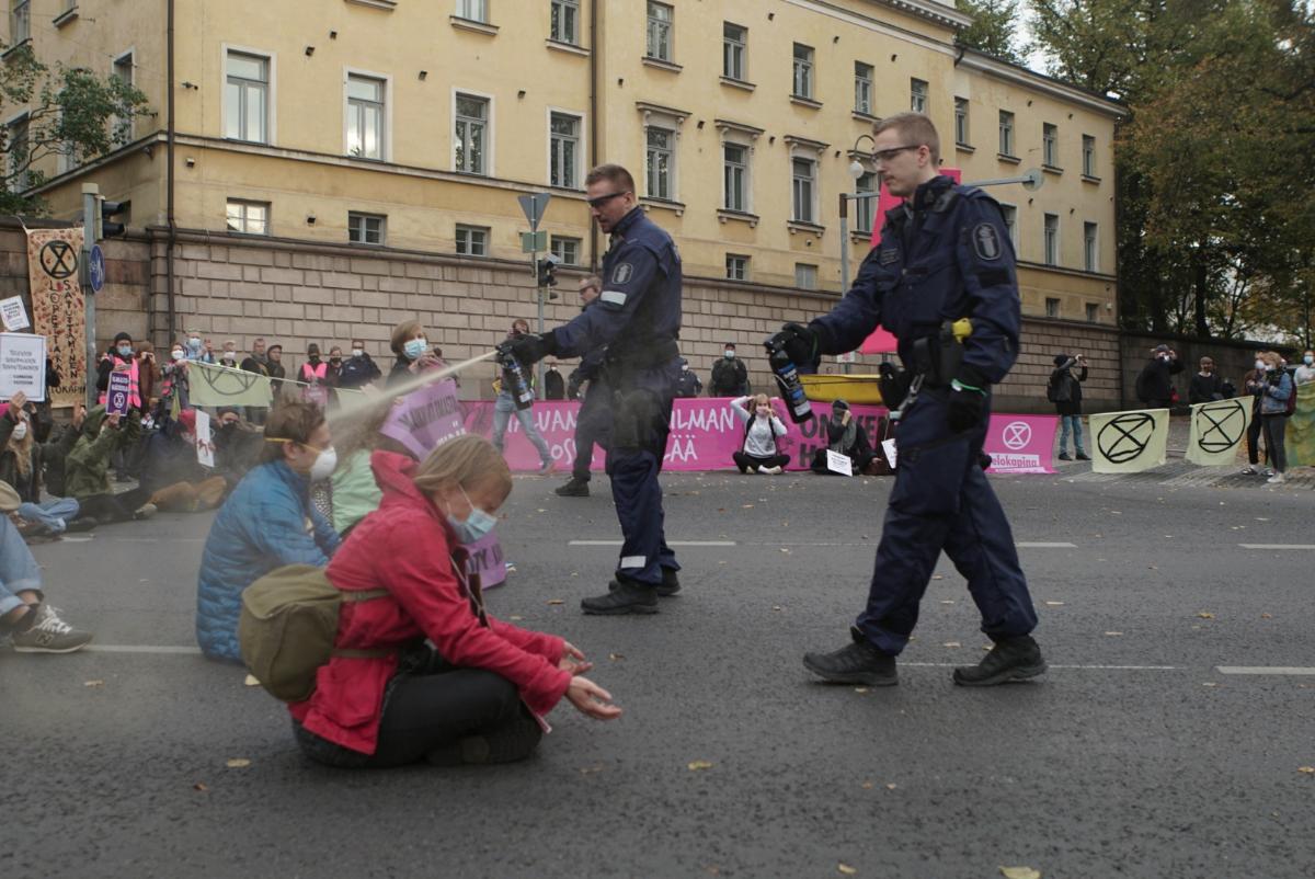 Poliisi suihkutti ilmastoaktivistien kasvoille OC-sumutetta sen jälkeen, kun he kieltäytyivät noudattamasta poistumiskäskyä. Elokapinan mukaan sumute aiheutti voimakkaita oireita noin kymmenelle ihmiselle. Mielenosoitus esti liikenteen Kaisaniemenkadulla. Kuva: Elokapina - Extinction Rebellion Finland