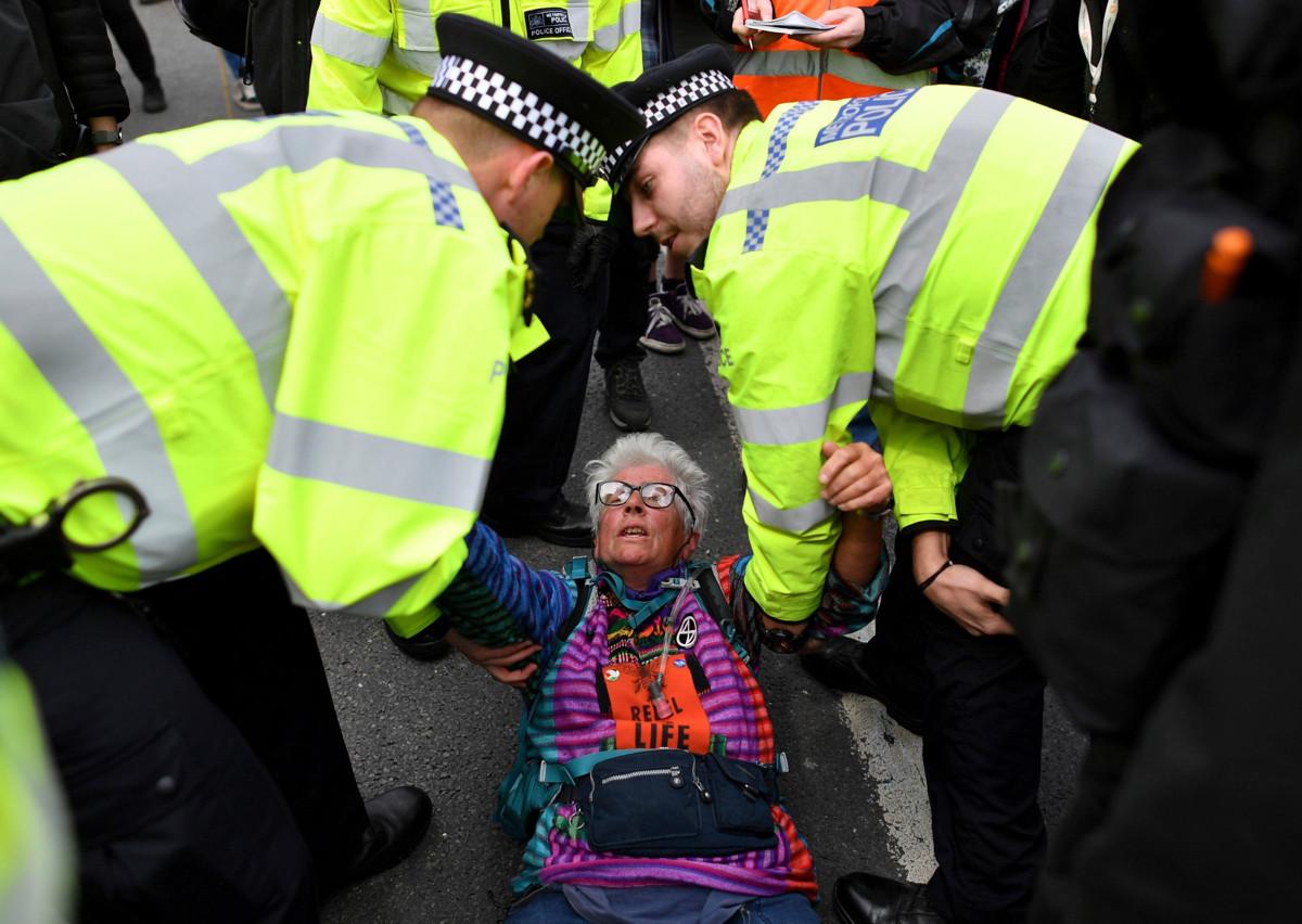 Lontoolaiset poliisit kantavat aktivistia, joka osallistui Waterloo-sillan sulkeneeseen Extinction Rebellion -liikkeen mielenosoitukseen. Mielenosoitukset sulkivat viisi Thames-joen ylittävää siltaa huhtikuussa 2019. Kuva: Ben Stansall Lehtikuva/AFP