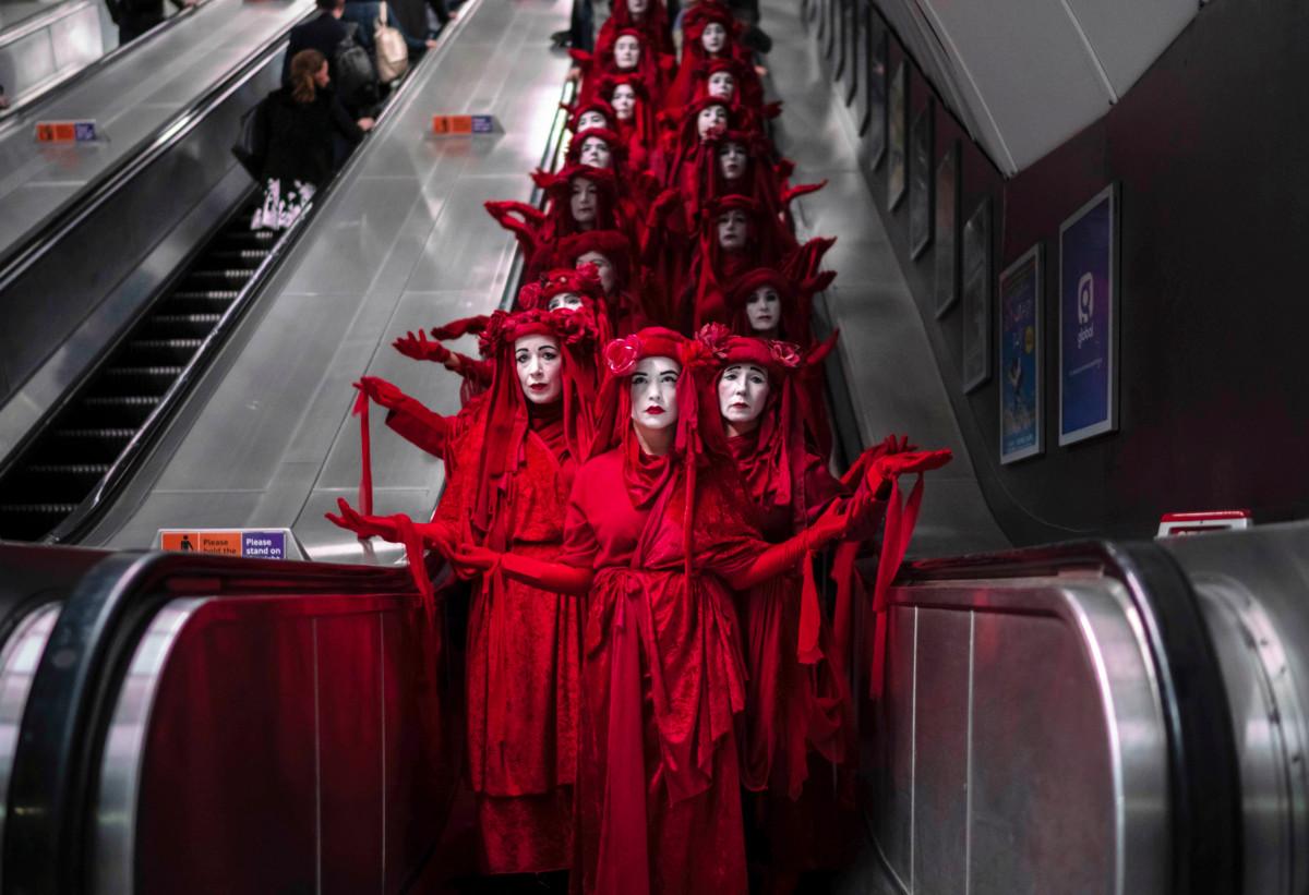 Puna-asuisten mielenosoittajien taideperformanssi lontoolaisella metroasemalla lokakuussa. Kuva: Yaz Ashmawi/Extinction Rebellion