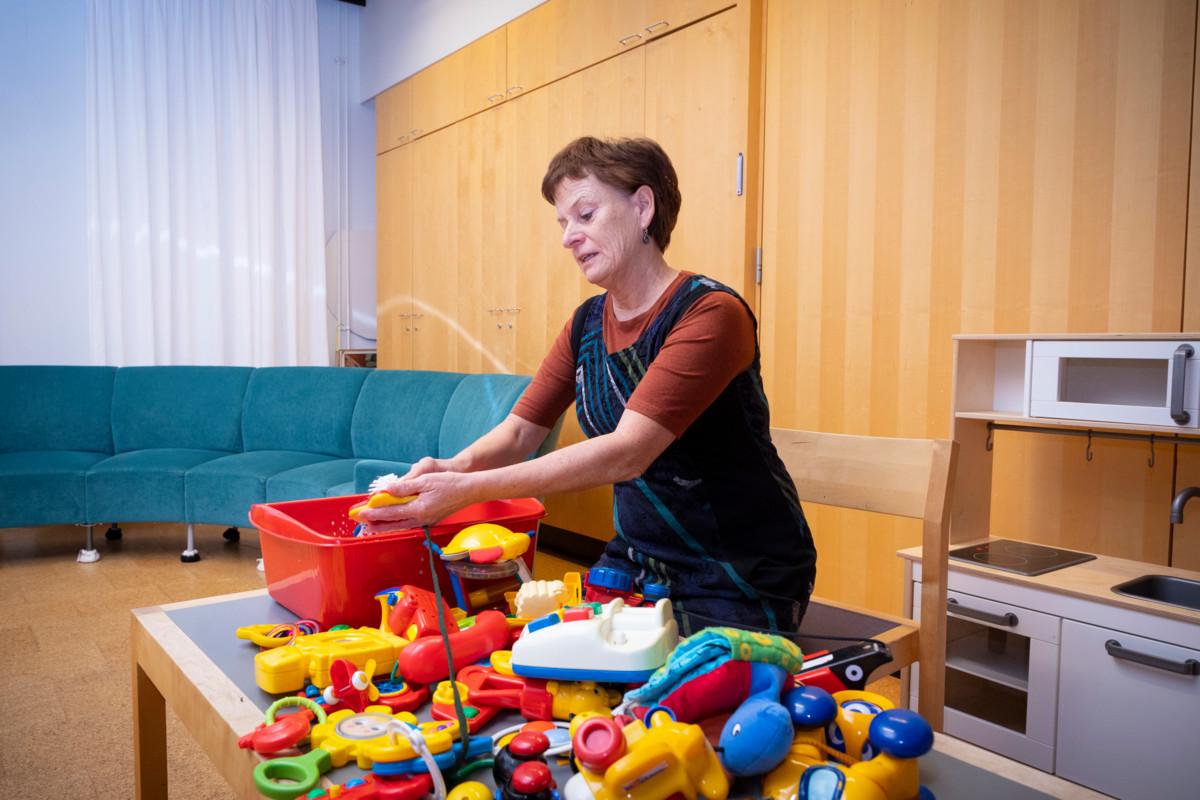 Lastenohjaaja Erja Lindholm pesee leluja Korson kirkolla.