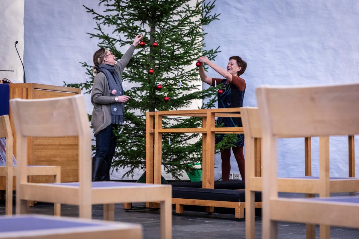 Joulu tulee kaikesta huolimatta. Suntio Katri Haapanen ja lastenohjaaja Erja Lindholm koristavat kuusta Korson kirkkosalissa.