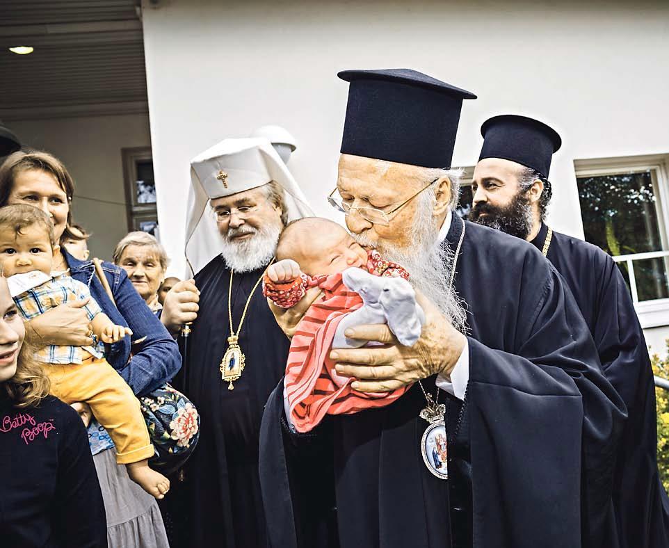 Neliviikkoinen vauva Haiko pääsi patriarkka Bartolomeoksen syliin. Patriarkan oikealla puolella on hänen seurueeseensa kuulunut arkkimandriitta Makarios, vasemmalla Suomen ortodoksisen kirkon arkkipiispa Leo.