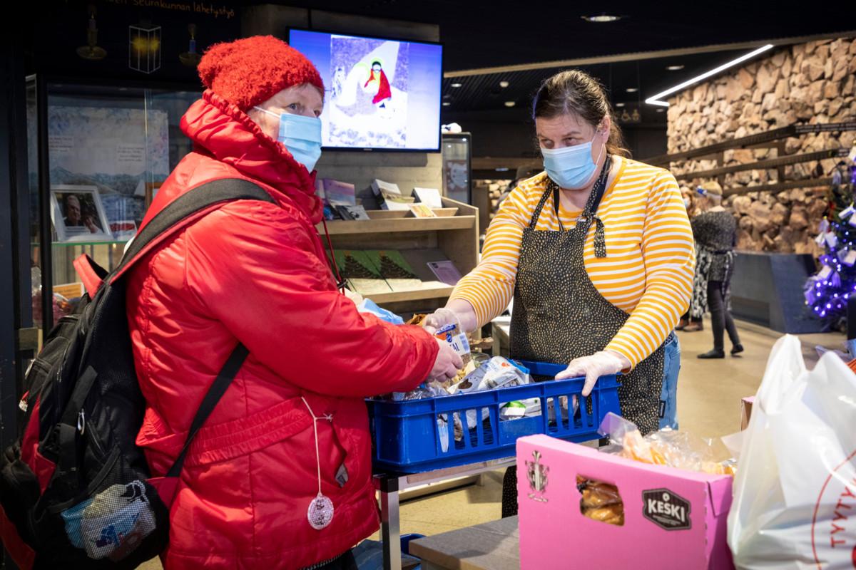 Espoonlahden kirkon elintarvikejakelu on tärkeä apu Helenalle (vas.). Hannele Elorannan lisäksi kirkolla on kymmeniä vapaaehtoisia, joiden varassa jakelu toimii.
